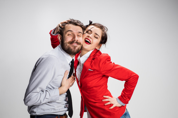 El hombre y la mujer de negocios abrazándose sobre un fondo gris
 - Foto, imagen