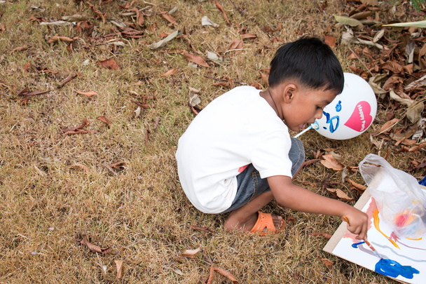 Cute little boy play paint in the garden - Foto, immagini