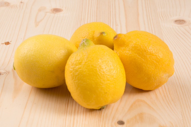 Lemon fruits on wooden background. Four lemon fruits - Foto, Imagen