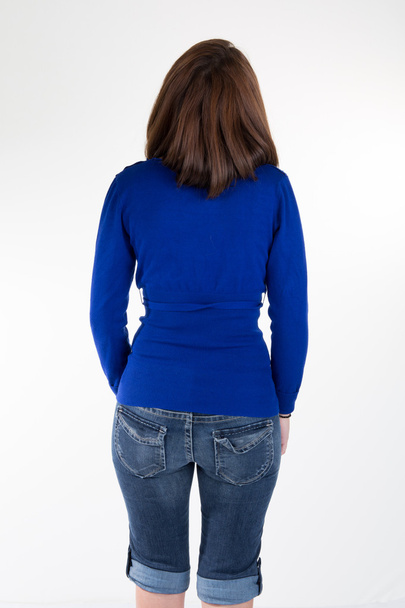Back view of brunette wearing blue denim jeans and blue top - Zdjęcie, obraz