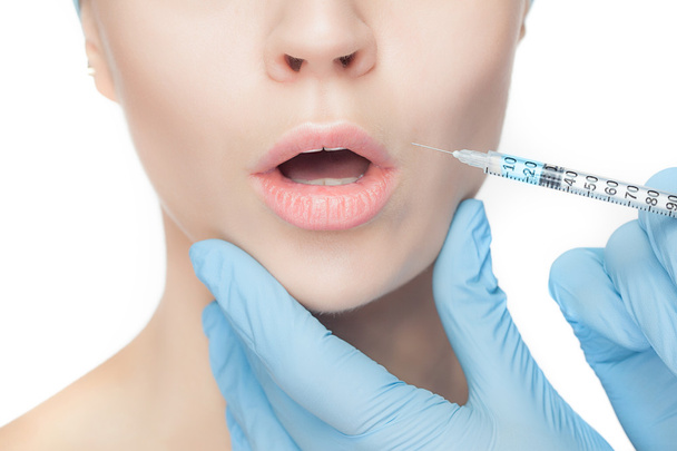 Attractive woman at plastic surgery with syringe in her face - Foto, Imagen