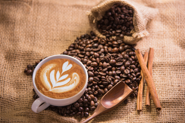 白いコーヒー カップと周りのローストのコーヒー豆 - 写真・画像