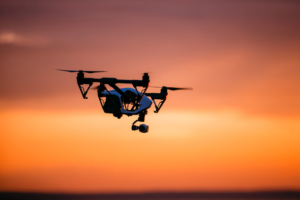 Uzaktan kumanda ile quadrocopter dron. Karanlık siluet Derma günbatımı karşı. Yumuşak odak. Tonlu görüntü - Fotoğraf, Görsel