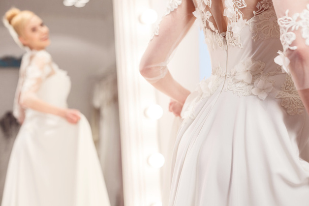 Beautiful young woman is trying on bridal clothing - Foto, imagen