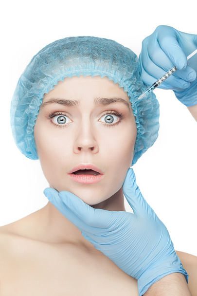 Attractive woman at plastic surgery with syringe in her face - Zdjęcie, obraz