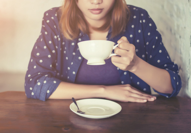 όμορφη γυναίκα χέρια με κύπελλο καφέ σε ένα τραπέζι από ξύλο - Φωτογραφία, εικόνα