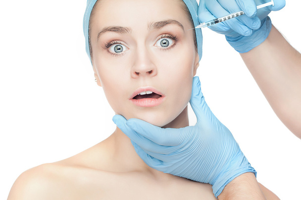 Mujer atractiva en cirugía plástica con jeringa en la cara
 - Foto, imagen