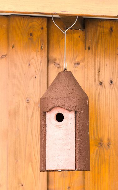 Птичий домик, висящий в деревянной хижине
 - Фото, изображение