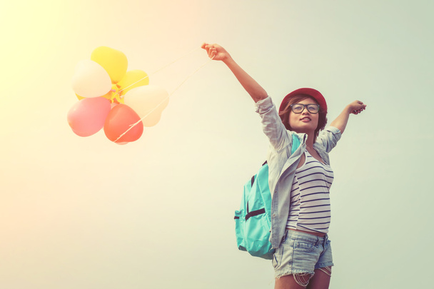 Εφηβικό κορίτσι φοράει γυαλιά, κρατώντας τα μπαλόνια χρωματιστό ώμου  - Φωτογραφία, εικόνα
