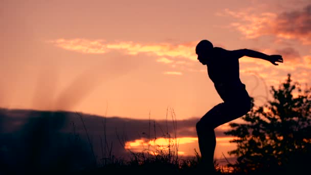 Gesunder junger Mann springt bei Sonnenuntergang - Filmmaterial, Video