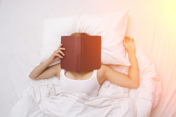 Bella giovane donna dormire sul letto dopo aver letto un libro con
 - Foto, immagini