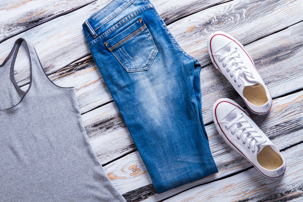 Jeans and gray tank top. - 写真・画像