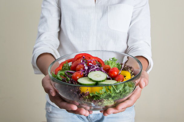 руки красивой женщины с большой миской свежего вегетарианского салата
  - Фото, изображение