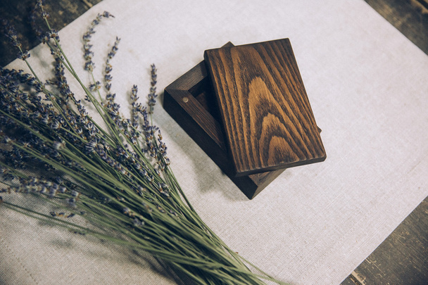 beautiful stylish wooden box lying on textile fabrics of cotton with lavender flower  - Foto, Imagem