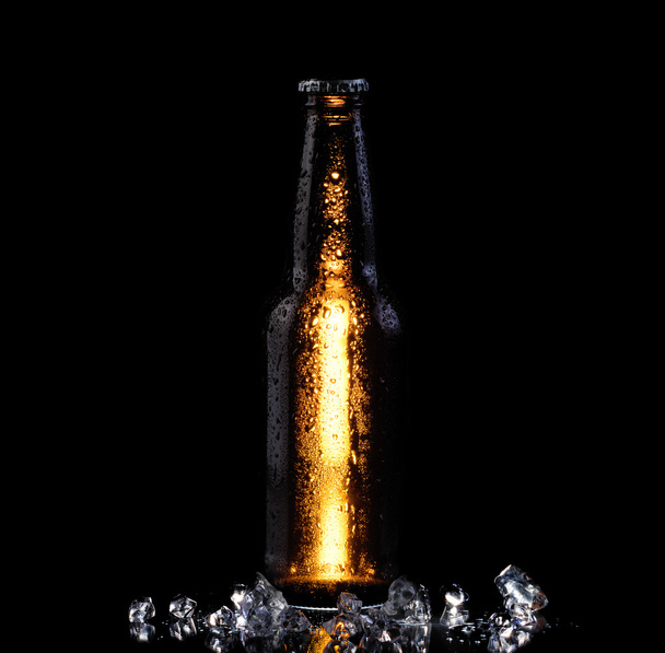 Ijs koud flesje bier op zwarte achtergrond  - Foto, afbeelding