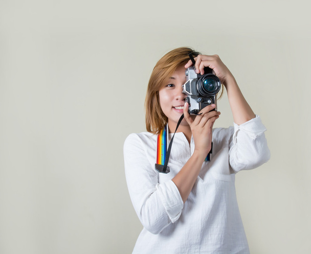 Όμορφη νεαρή γυναίκα φωτογράφος κρατώντας κάμερας ρετρό  - Φωτογραφία, εικόνα