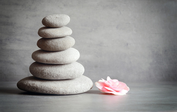 Zen-Steine und Begonien-Blume auf grauem Hintergrund - Foto, Bild