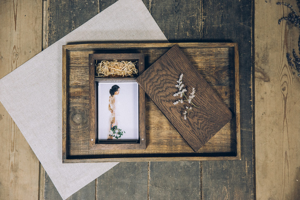 wooden box for photos with a photograph lying on a wooden tray beautiful stylized stylish fine art under the film with beautiful photography - Photo, Image