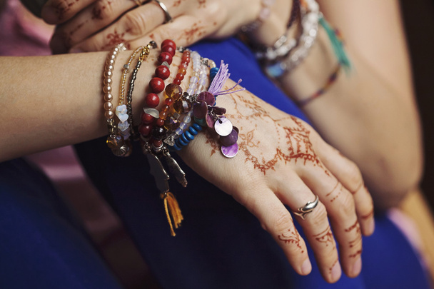 Жіночі руки з мінді і багато браслетів
 - Фото, зображення