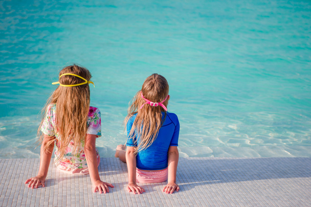 Adorable little girls in swimming pool on summer vacation - Photo, Image