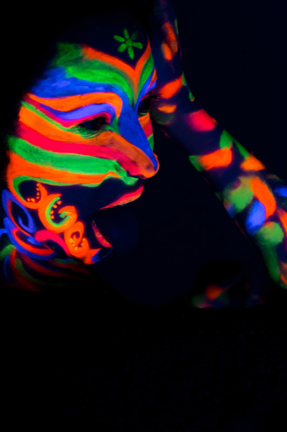 Nainen, jolla on hohtavaa UV-fluoresoivaa jauhetta
 - Valokuva, kuva