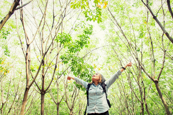 schöne junge Frau trägt Rucksack zu Fuß in Wald stretc - Foto, Bild