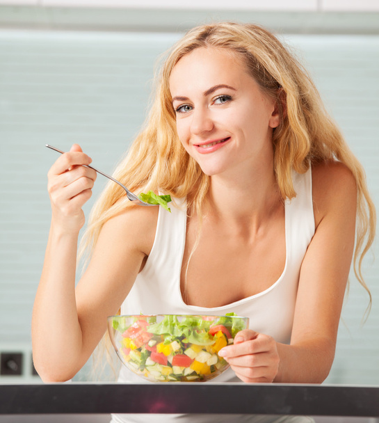 Zöldségsalátát evő fiatal nő  - Fotó, kép