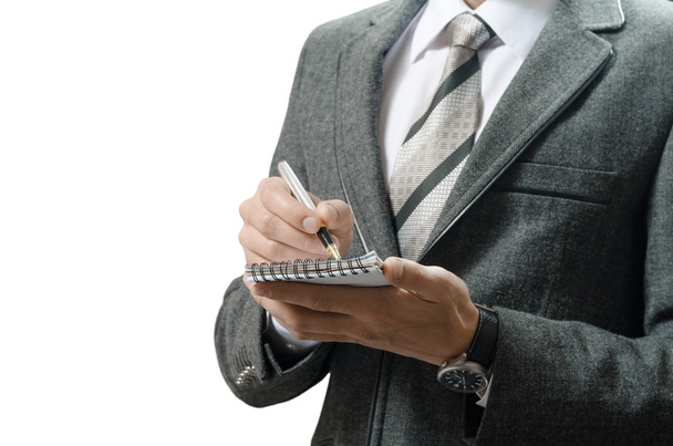 homem de negócios em um terno põe dados no caderno
 - Foto, Imagem