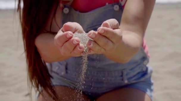 Sand falling through hands of woman - Materiał filmowy, wideo