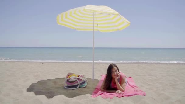 Lady ustanawiające na plaży koc - Materiał filmowy, wideo