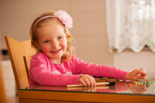 Ładny mały pin dziewczyna wskazujące bloki do deski drewniane, grając w - Zdjęcie, obraz