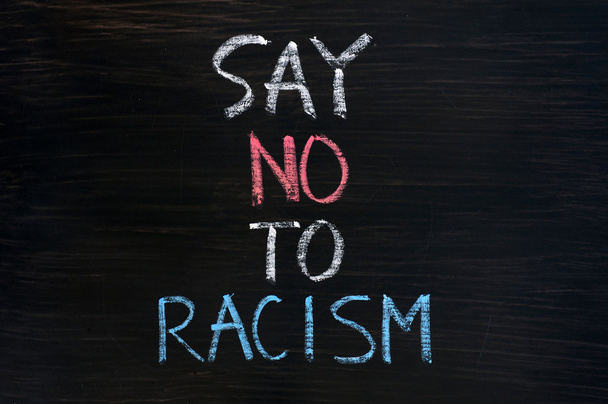 Decir no al racismo escrito en un fondo de pizarra manchada
 - Foto, Imagen