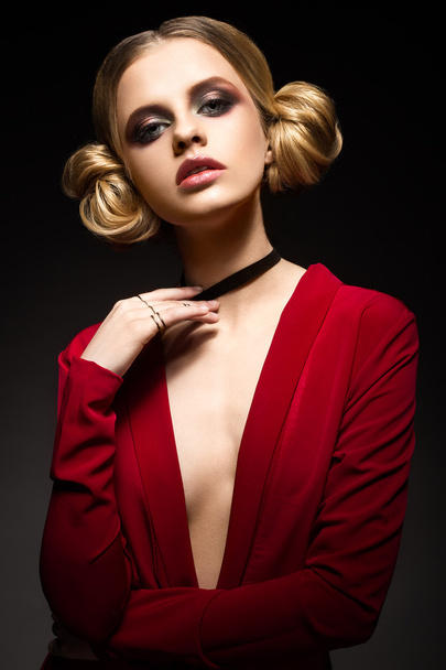 Beautiful girl in a red dress with a deep neckline and black rings on his fingers. The model with bright makeup. - Фото, зображення