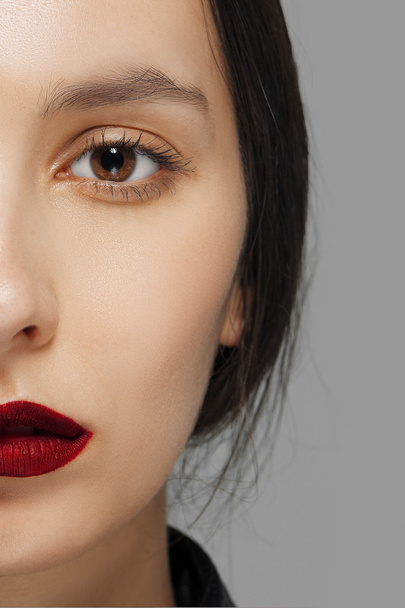 half face of fashion model with tan makeup and red mat lips - Photo, Image
