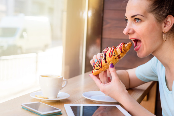 woman eating a croissant - Photo, Image