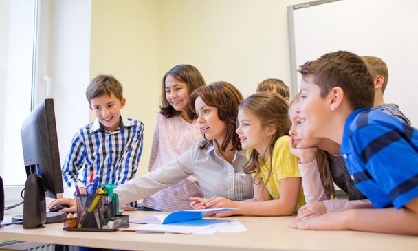 group of kids with teacher and computer at school - 写真・画像