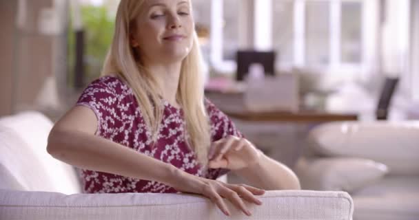 woman relaxing on white couch and daydreaming - Filmagem, Vídeo