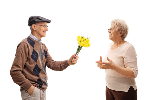 senior man giving flowers to a lady  - Фото, изображение