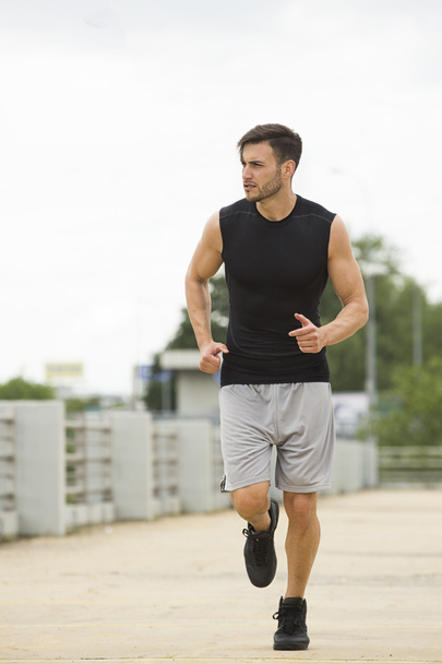 Handsome man jogging outdoors - Photo, Image