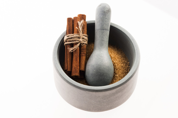 Cinnamon sticks with pure cane brown sugar in mortar - Photo, Image