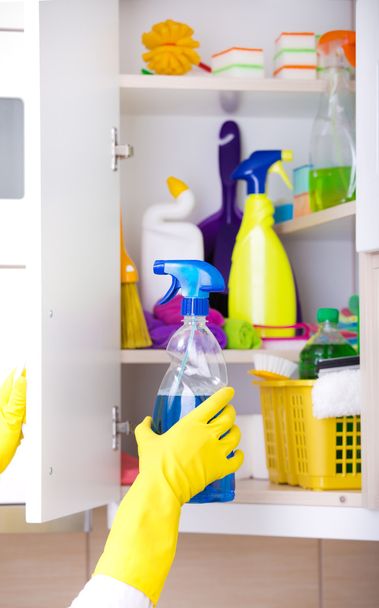 Woman storing cleaning tools in pantry  - 写真・画像