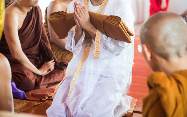Nahaufnahme eines neu geweihten buddhistischen Mönchs, der mit Priesterprozeduren betet - Foto, Bild