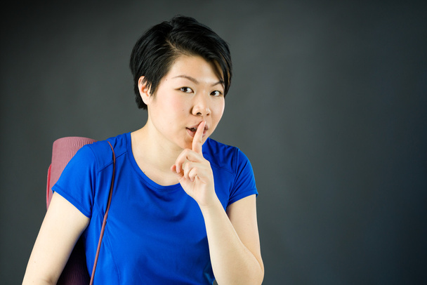 Frau bittet mit Finger auf Lippen um Schweigen - Foto, Bild