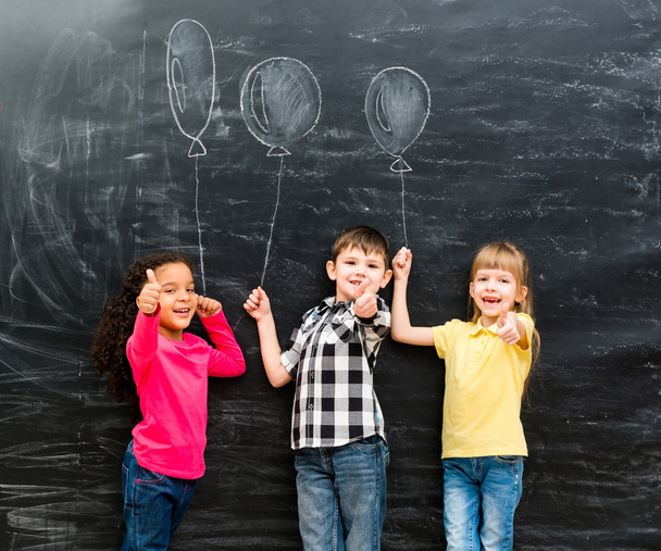 három mosolygó gyermek tartása imaginaru remek készült léggömbök - Fotó, kép