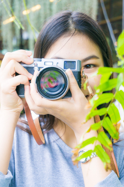 Söpö hipster nuori naisvalokuvaaja kameran kanssa ulkona puistossa
 - Valokuva, kuva