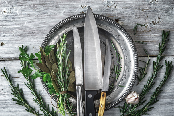 Metal plate with knifes and different  herbs on the white table top view - Foto, Bild