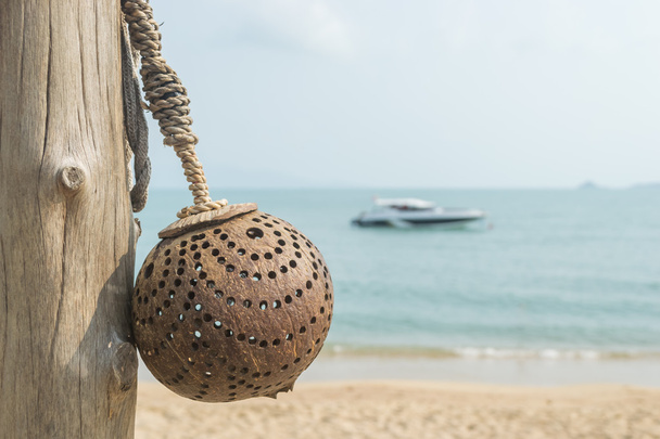 Lampe aus Kokosnussschalen mit Boot und Strand verschwimmen Hintergrund. - Foto, Bild