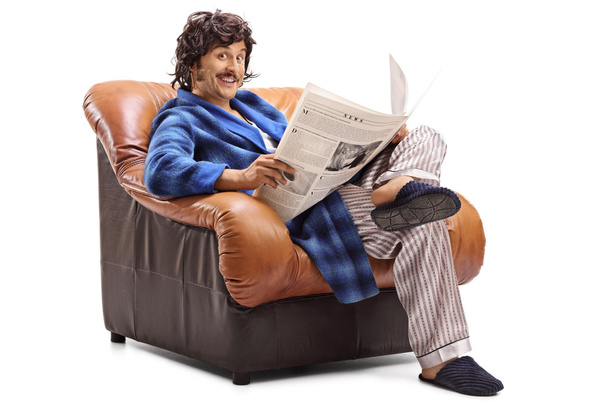 Man reading the newspaper seated in an armchair  - Fotó, kép