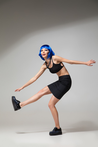 Smiling woman in blue wig in motion - Photo, Image