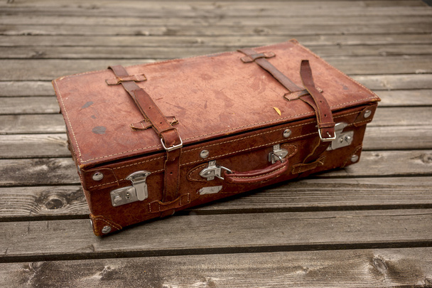Vintage leather suitcase on a wooden deck - Φωτογραφία, εικόνα
